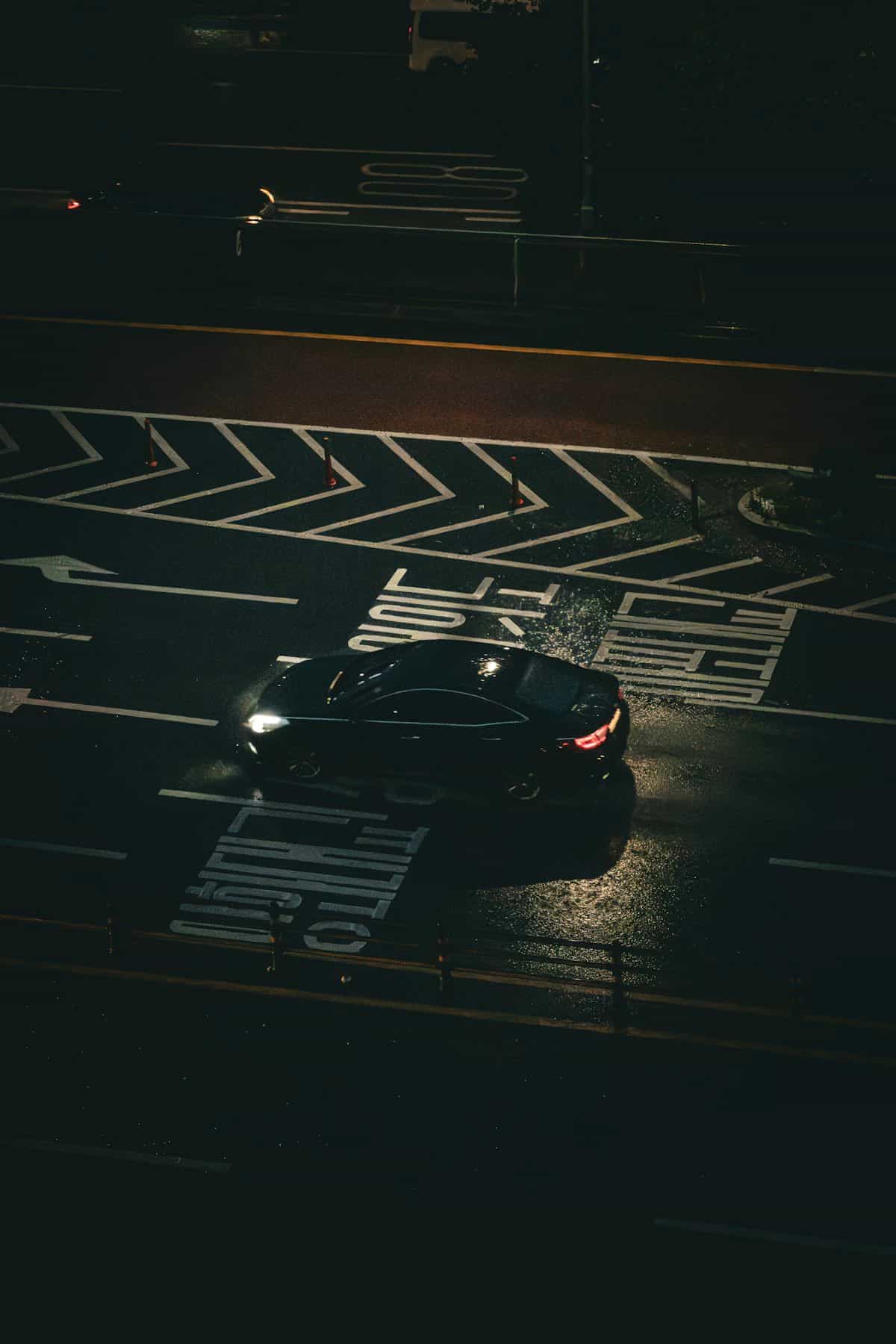 Berlina negra cruzando un paso urbano de noche